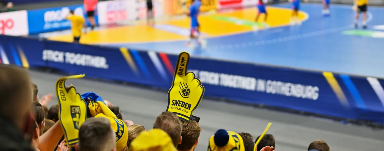 Svenska fans på läktaren under en handbollsmatch i Göteborg, en stad känd för sina stora sportevenemang.