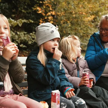 Barn och vuxna njuter av en picknick i Slottsskogen, en av Göteborgs mest barnvänliga platser.