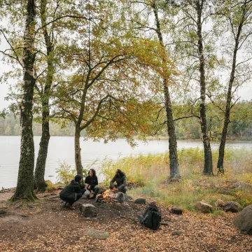 Lägereld vid Delsjön, en populär plats för familjevänliga naturutflykter och friluftsaktiviteter i Göteborg.