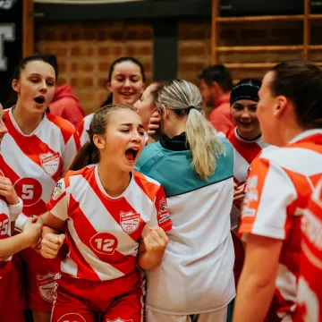 Ett ungdomslag firar en vinst i en internationell idrottsturnering. Gemenskap och glädje under stora sportevenemang.
