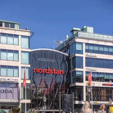 Entrén till Nordstan i Göteborg, där människor rör sig mellan butiker och restauranger i ett av Sveriges största shoppingcenter.