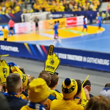 Svenska fans på läktaren under en handbollsmatch i Göteborg, en stad känd för sina stora sportevenemang.